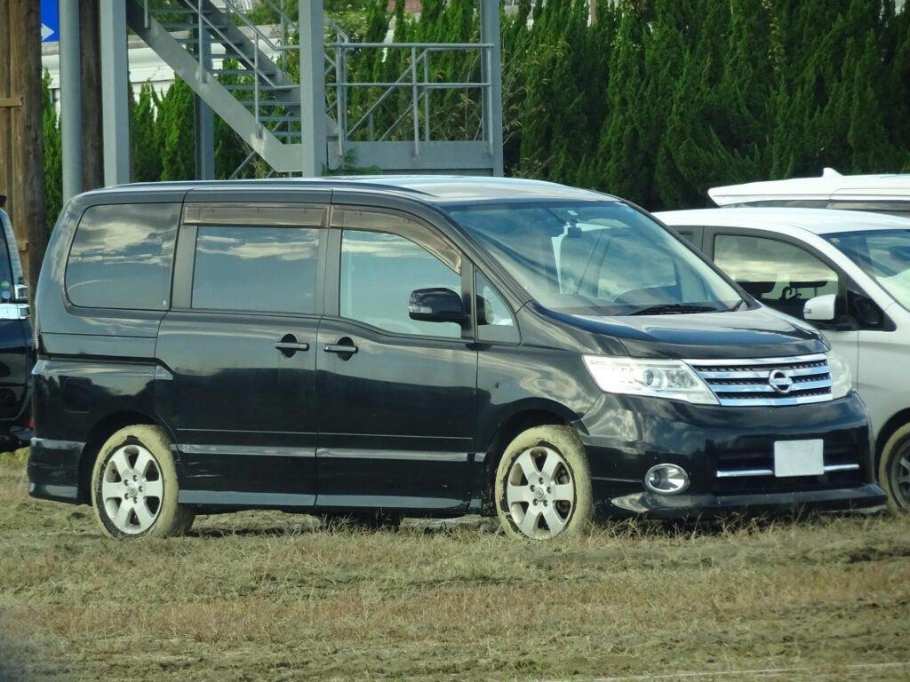 芝生の駐車場に停まる黒のセレナ