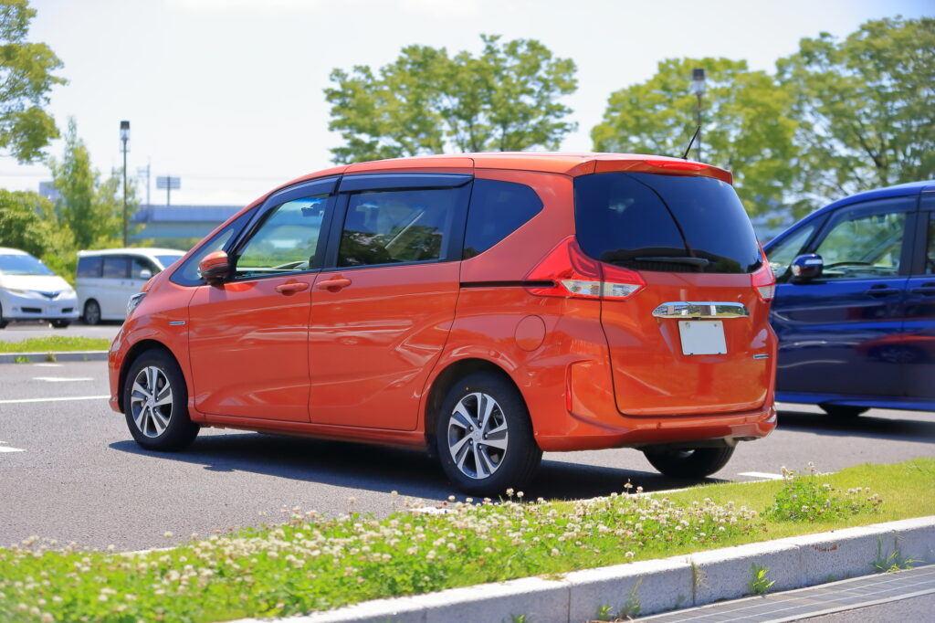 駐車場に停車するオレンジのフリード