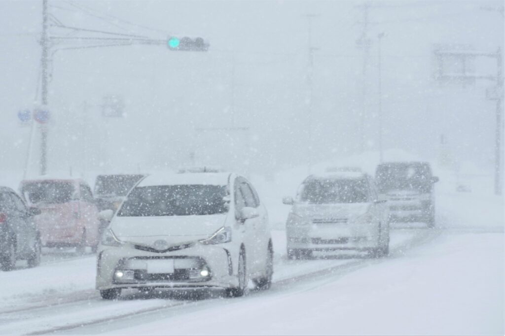 悪天候の中を走行する車がフォグランプを点灯している様子