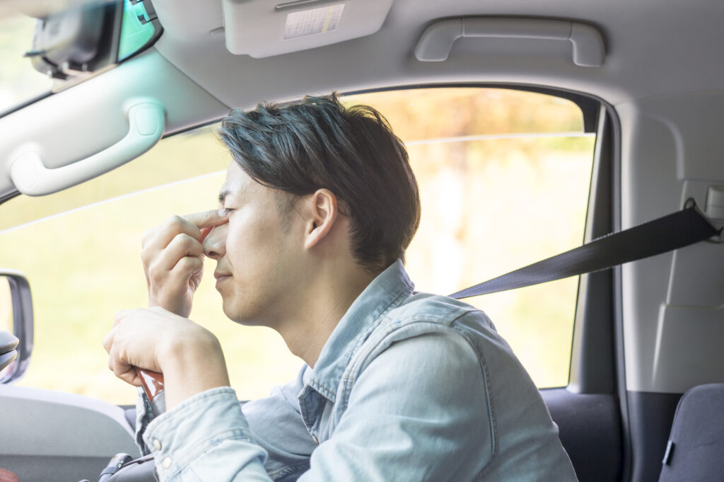 運転による目の疲れを感じている男性