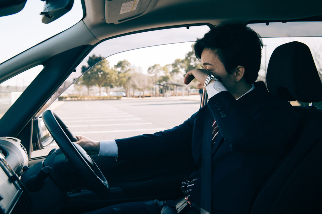 運転中に眠気を感じる男性