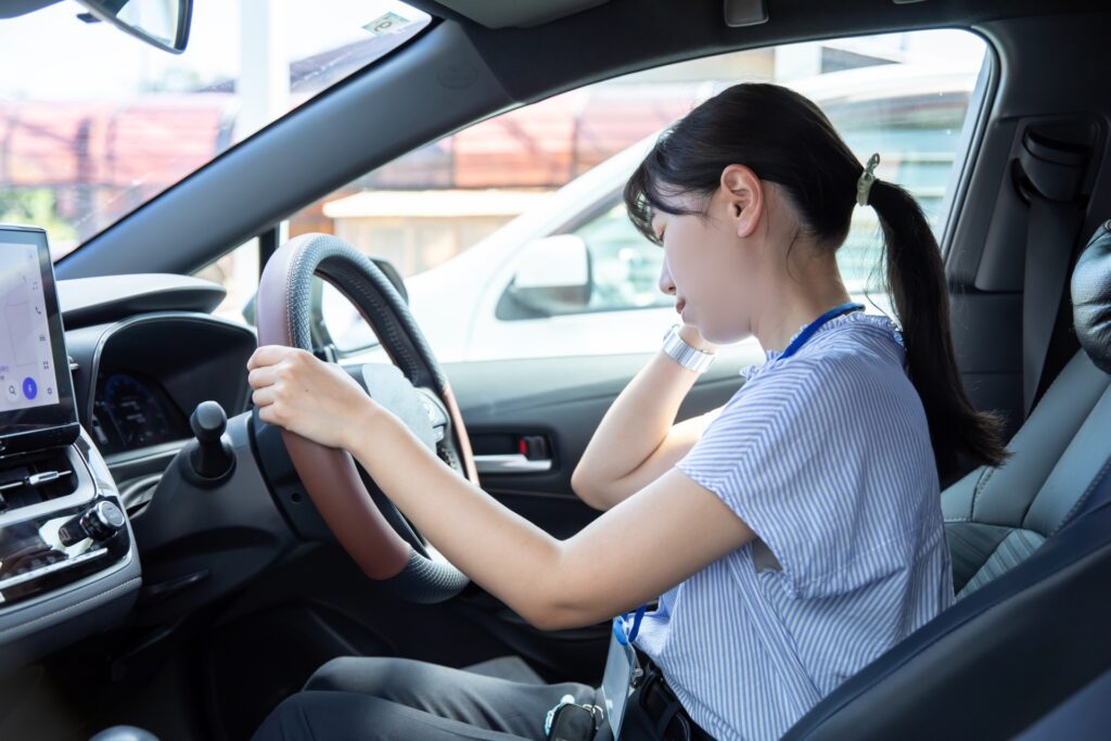 車が故障して困る女性の様子