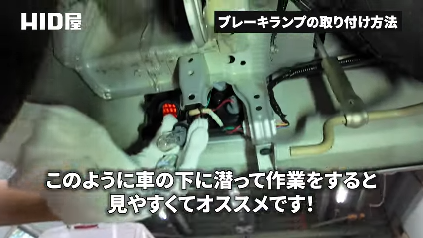 車の下に潜り込んで作業する様子