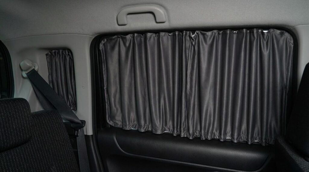 車中泊で窓にシェードを設置している様子