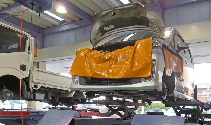 車検専門店でメンテナンス中の軽自動車