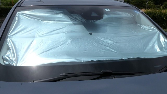 傘タイプの車用サンシェードをフロントガラスに装着しているイメージ