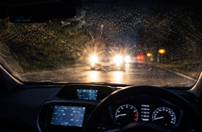 対向車のライトが花粉汚れによって反射しているフロントガラス
