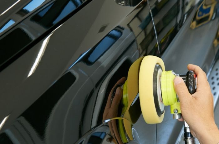 中古車(黒)にコーティングをかけている様子