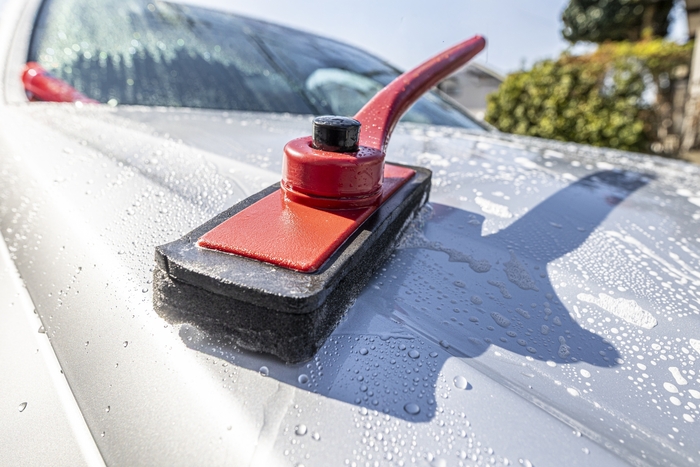 白い車を洗車している画像