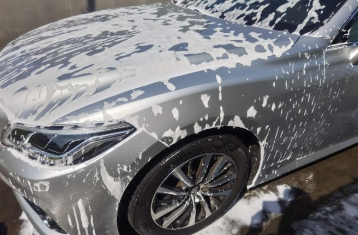 シルバーの車を洗車している様子