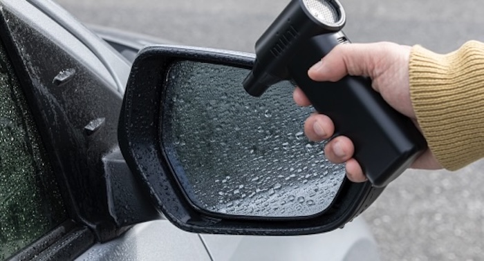 ブロワーでドアミラーの水滴を飛ばしている様子
