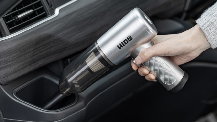 コンパクトハンディクリーナーで車内を掃除する様子
