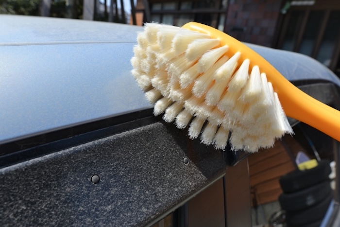 硬いブラシで洗車する様子