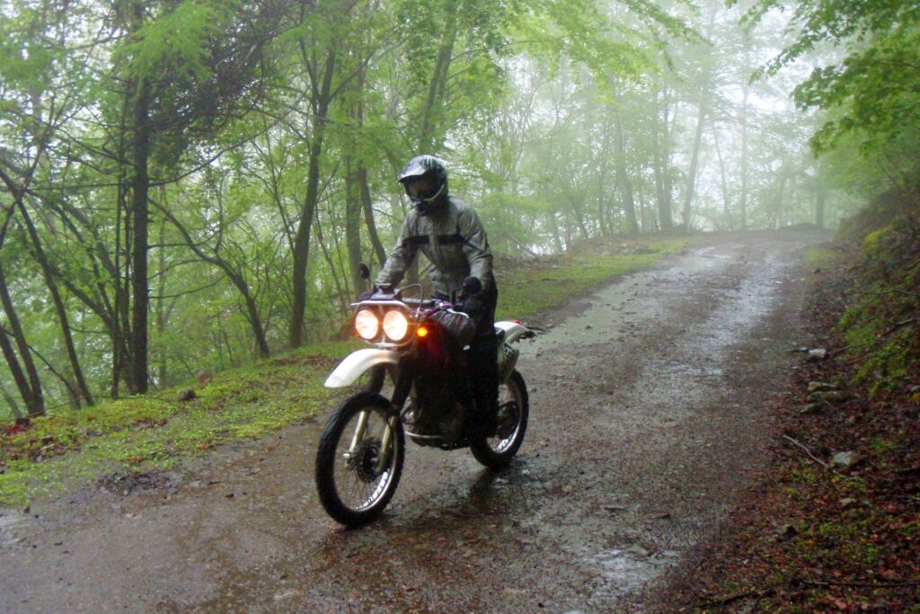 レインウェアを着たライダーとオフロードバイク