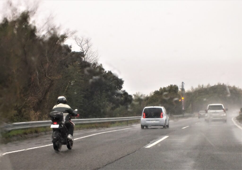 雨天時に車間距離を広げて走行するバイク