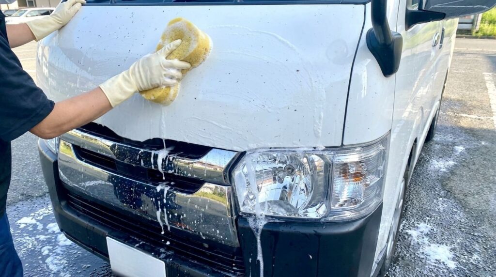 車についた虫汚れを手洗い洗車している様子