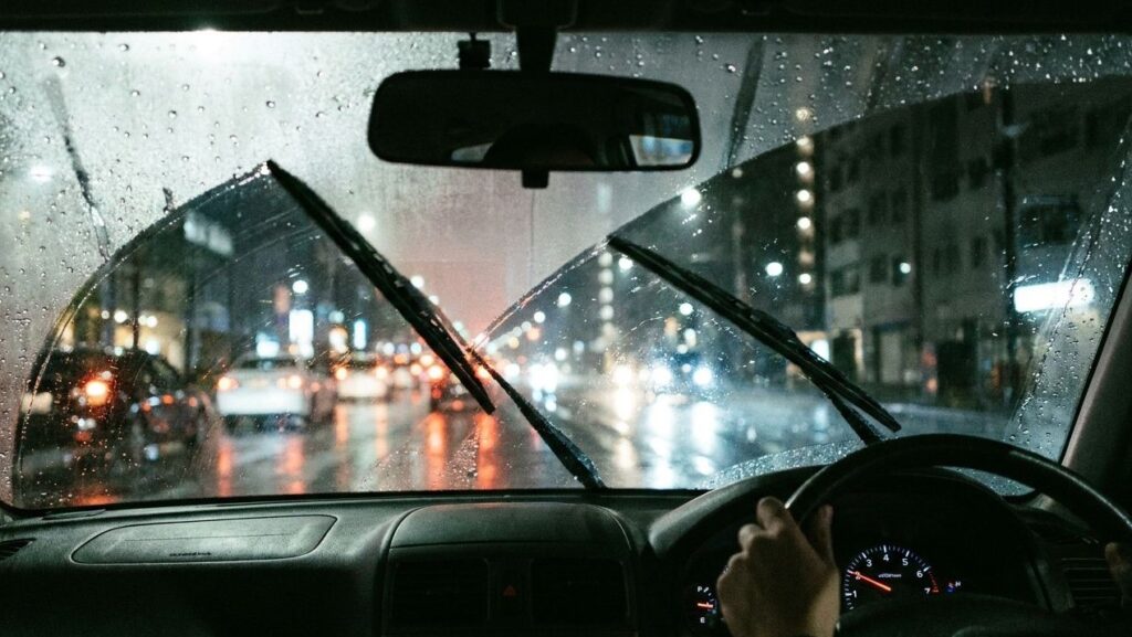 車のフロントガラスの外側の曇りがワイパーで解消される様子