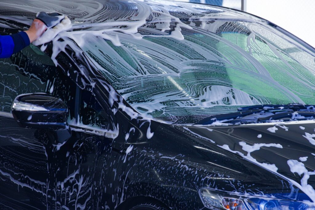 カーシャンプーをつけたスポンジを使って洗車する様子